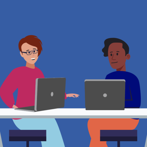 two people talking at a desk